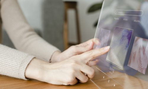 Woman using transparent tablet to play the music innovative technology